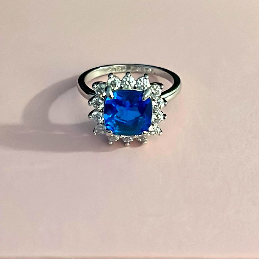 NWOT-size 8 blue sapphire and white topaz ring on a triple rhodium plated band.